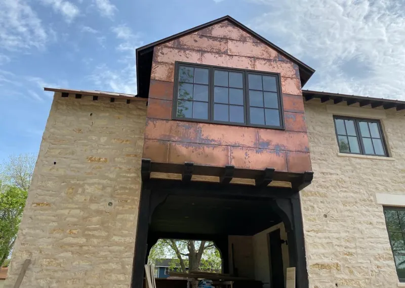 Copper metal panel facade on a stone building for Skylight Installation in Wharton